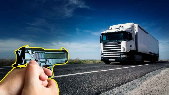 Fotografia de um caminhão em rodovia sob a mira de uma pistola, ilustrando uma tentativa de assalto a caminhão